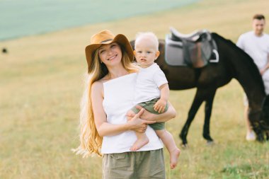 Genç bir aile eğlenceli bir alanı var. Anne ve çocuk bir atı ile