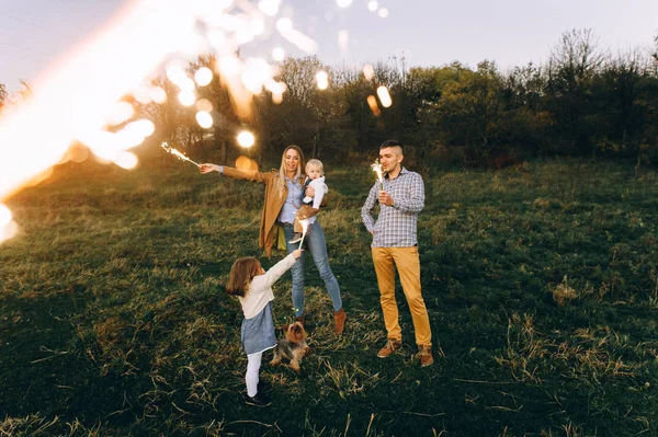 Lycklig Familj Med Bengal Lampor Ett Grönt Fält Vid Solnedgången — Stockfoto