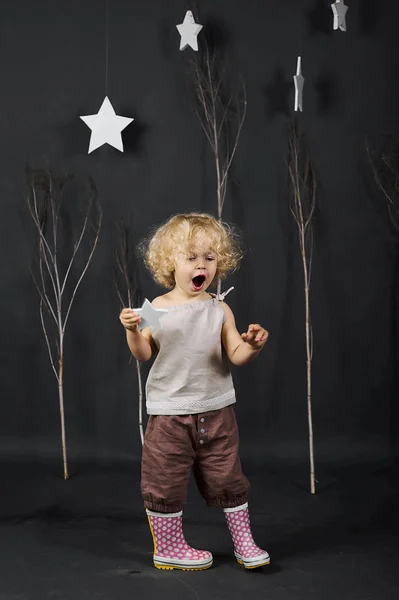 Lustige Lockige Kleine Mädchen Auf Grauem Hintergrund Mit Bäumen — Stockfoto