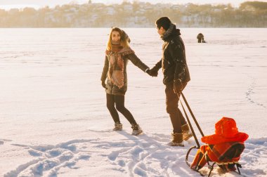 Ebeveynlik, moda, sezon ve insanlar kavramı - çocuk üzerinde kızak kış havada yürüyüş ile mutlu aile