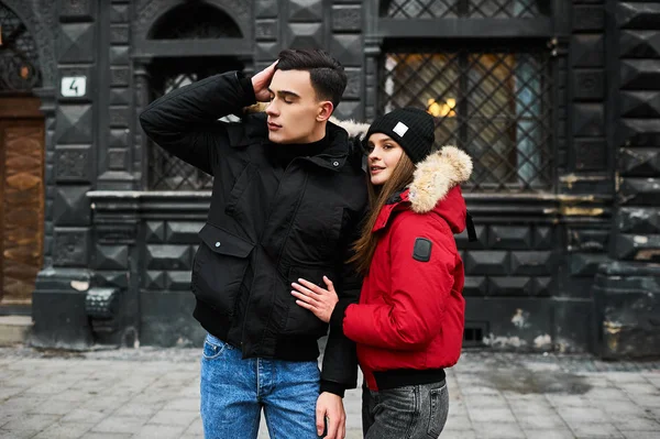 A trendy young couple walks in the city at christmastime