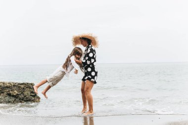 Anne ve kızı elele ve sahilde yürüyüş. Anne ve 