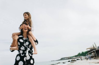 Anne ve kızı elele ve sahilde yürüyüş. Anne ve 