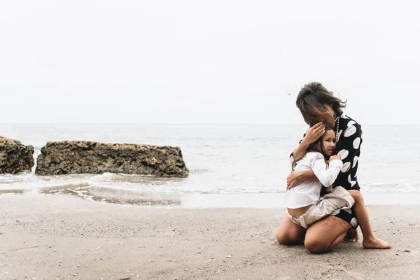 Mor och dotter höll händer och promenader på stranden. Mamma och — Stockfoto