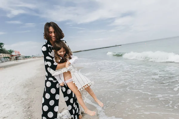 Mãe e filha de mãos dadas e andando na praia. Mãe e... — Fotografia de Stock