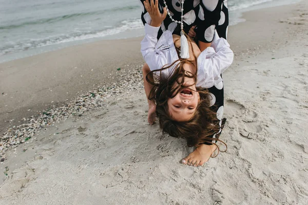 Mor och dotter höll händer och promenader på stranden. Mamma och — Stockfoto