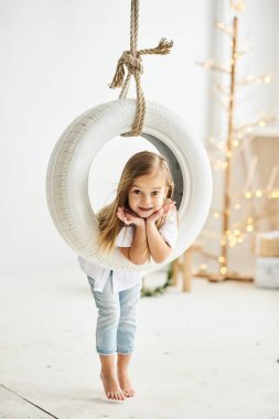 Beyaz r bir salıncak tekne ile oynarken güzel küçük bir kız