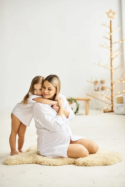 Mutlu hamile anne ve kızları birbirlerine sarılmak — Stok fotoğraf