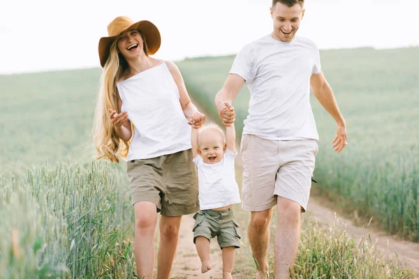 Una giovane famiglia si diverte con il loro bambino sul campo — Foto Stock