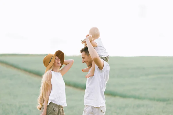 Una giovane famiglia si diverte con il loro bambino sul campo — Foto Stock