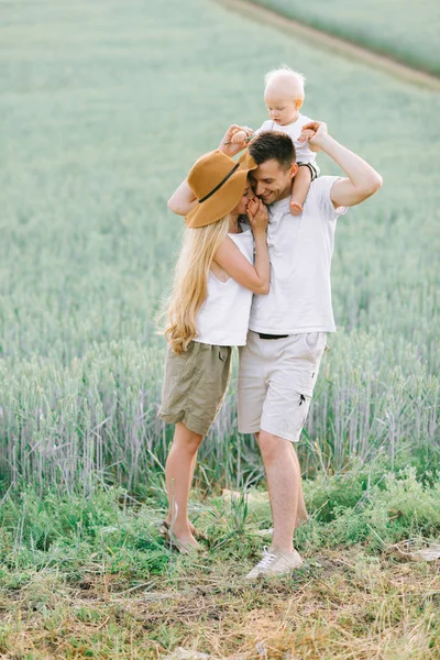 Una giovane famiglia si diverte con il loro bambino sul campo — Foto Stock