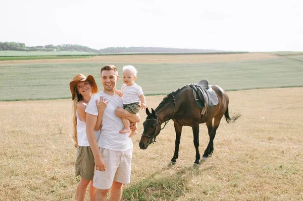 A young family have a fun in the field. Parents and child with a — Stock Photo, Image