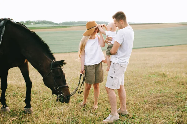 Una familia joven se divierte en el campo. Padres e hijos con un —  Fotos de Stock