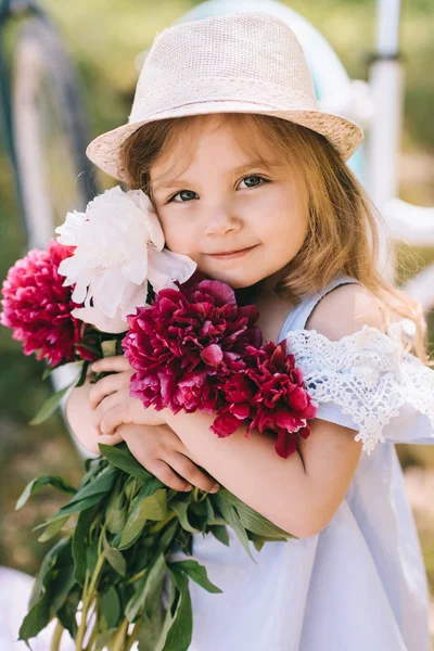 Portret dziewczynki uśmiechający się z wielkim bukietem kwiatów na — Zdjęcie stockowe