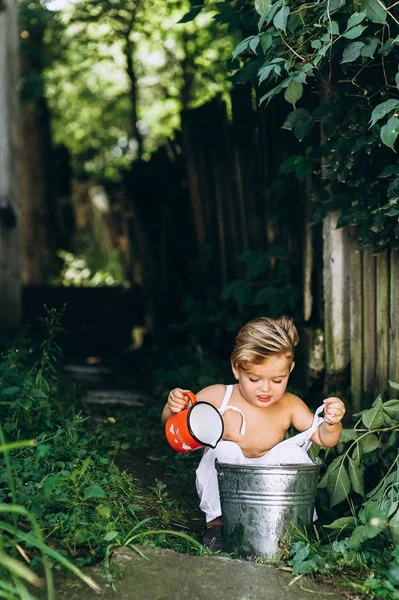 Beautiful boy with white hair and a combination is played with a — Stock Photo, Image