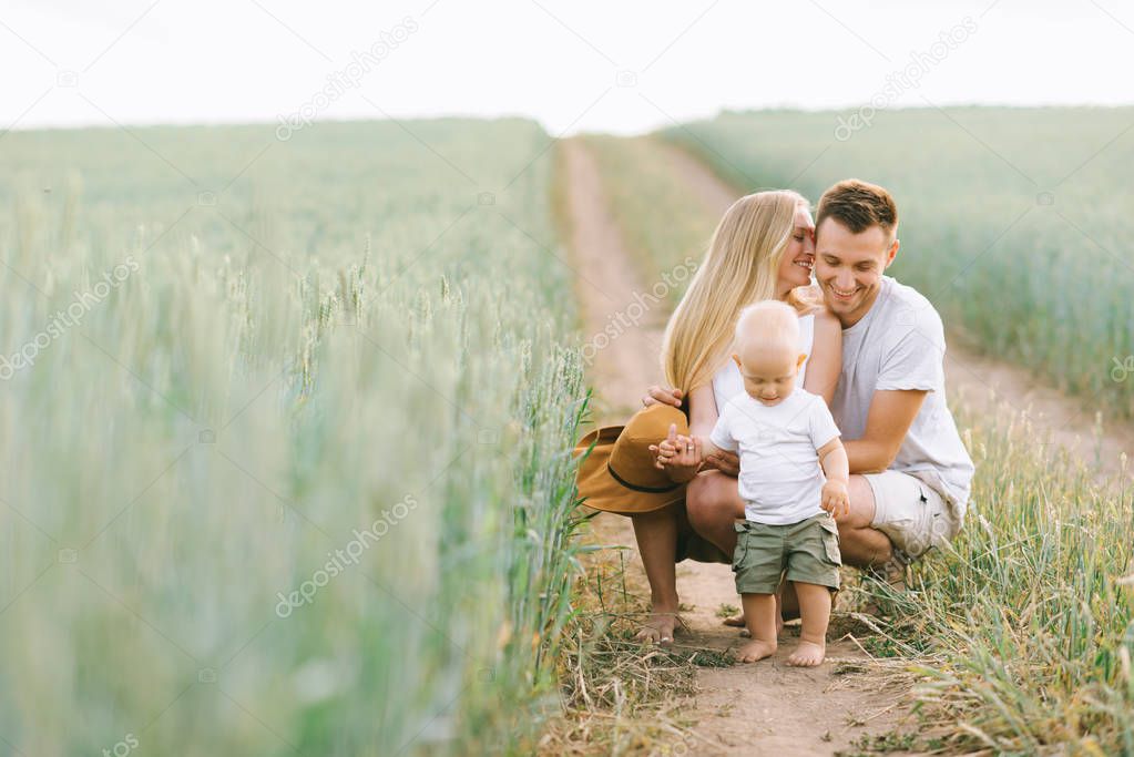 A young family have a fun with their little baby in the field