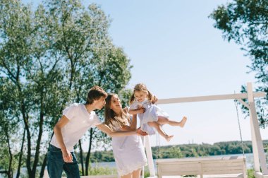 Mutlu bir aile açık havada birlikte vakit. Baba, anne ve kızı bir plajda piknik içinde