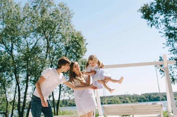 Mutlu bir aile açık havada birlikte vakit. Baba, anne ve kızı bir plajda piknik içinde