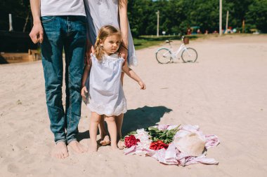 Mutlu bir aile açık havada birlikte vakit. Baba, anne ve kızı bir plajda piknik içinde