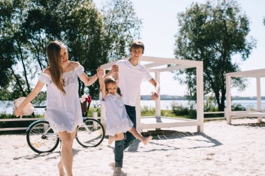 Mutlu bir aile açık havada birlikte vakit. Baba, anne ve kızı var eğlenceli bir ve bir kumsalda oynarken