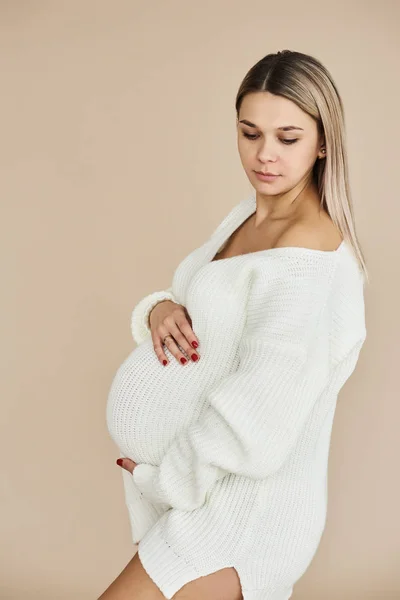 Portret Piękna Dziewczyna Ciąży Ubrany Biały Sweter Beżowym Tle — Zdjęcie stockowe