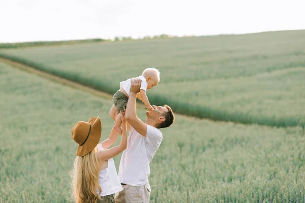 Une jeune famille s'amuse avec son petit bébé sur le terrain — Photo