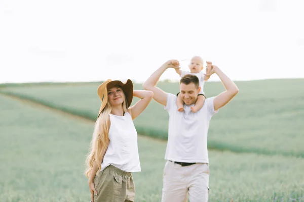 Een jong gezin een plezier hebben met hun kleine baby in het veld — Stockfoto