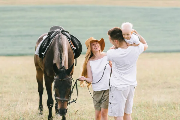 En ung familj har en rolig i fältet. Föräldrar och barn med en — Stockfoto