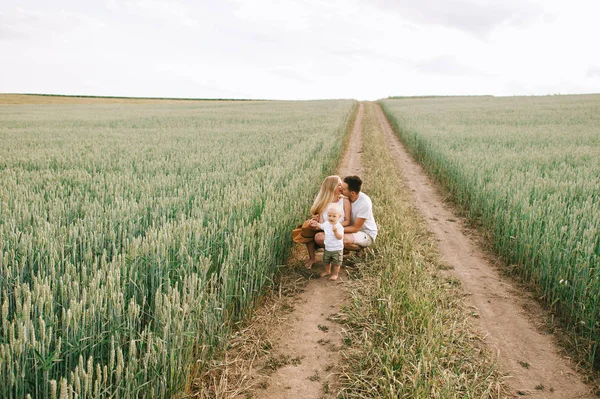 Uma jovem família se diverte com seu bebê no campo — Fotografia de Stock