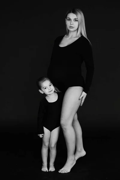 Ett porträtt av vackra gravid mamma med sin lilla dotter — Stockfoto