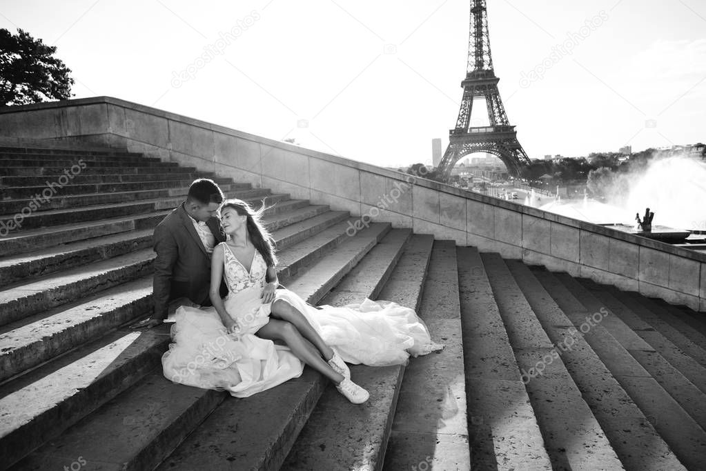 Happy romantic married couple hugging near the Eiffel tower in P