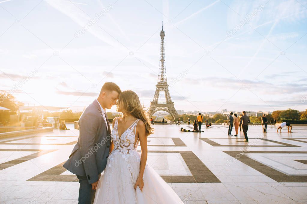 Happy romantic married couple hugging near the Eiffel tower in P