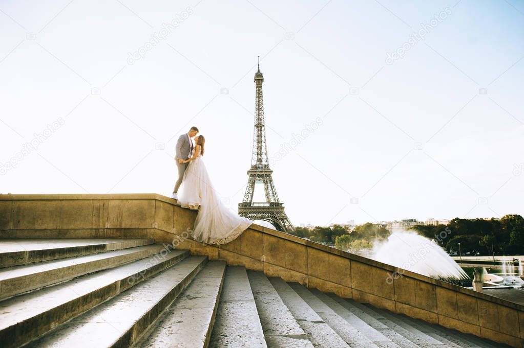 Happy romantic married couple hugging near the Eiffel tower in P