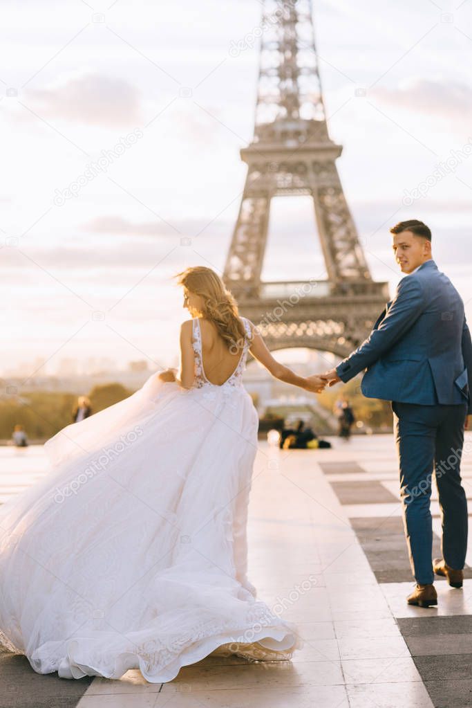 Happy romantic married couple hugging near the Eiffel tower in P