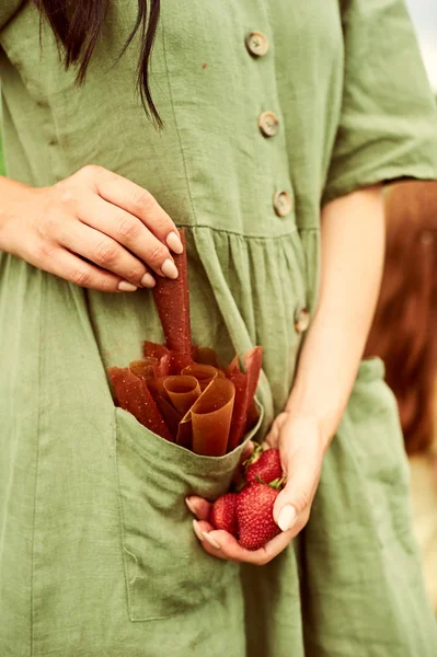 Pastilla en aardbeien in de handen van een jonge vrouw gekleed — Stockfoto
