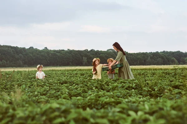 Hermosa joven madre caucásica con niños en un vestido de lino —  Fotos de Stock