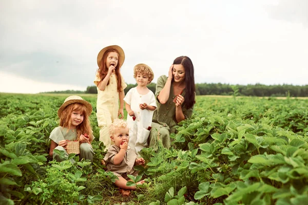 Beautiful young caucasian mother with children in a linen dress — Stock Photo, Image