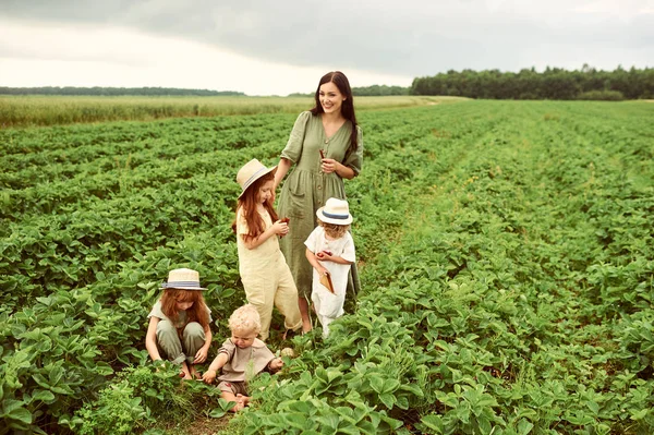 Hermosa joven madre caucásica con niños en un vestido de lino —  Fotos de Stock