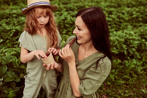 Beautiful young mother with her daughter having fun on a green f — Stock Photo, Image