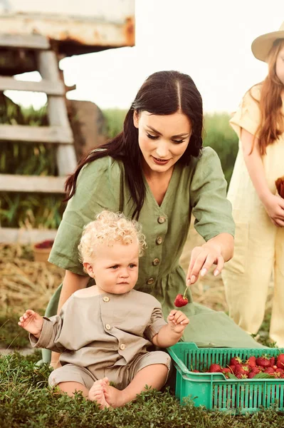 Vackra unga kaukasiska mor med sina barn i en linne Dr — Stockfoto