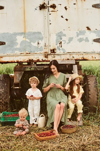 Beautiful young caucasian mother with her children in a linen dr — Stock Photo, Image