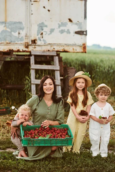 Vackra unga kaukasiska mor med sina barn i en linne Dr — Stockfoto