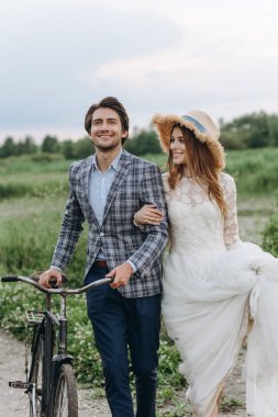 Genç ve güzel bir çift gelin ve damat bir tarlada yürüyor.