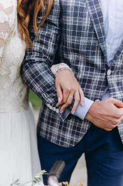 Güzel genç çift gelin ve damat ağaçların arasında yürüyorlar.