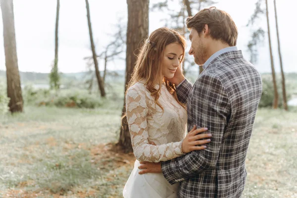 Um jovem casal de noivas andando na floresta de pinheiros — Fotografia de Stock