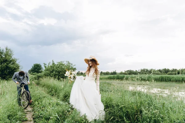 Belle jeune mariée couple et marié marche dans un champ avec un — Photo