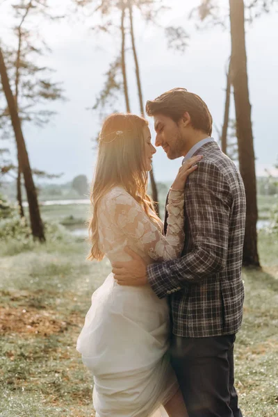 Um jovem casal de noivas andando na floresta de pinheiros — Fotografia de Stock