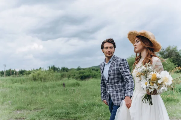 Um jovem casal de noivas se divertir e caminhar no campo para fora — Fotografia de Stock