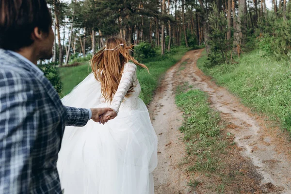 Un jeune couple de mariées marchant dans la forêt de pins — Photo