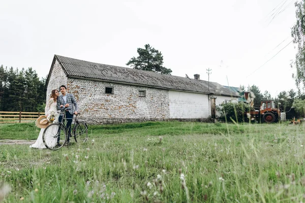 Un beau jeune couple marié et marié avec un vélo près de vieux — Photo